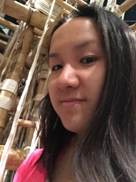 Angela Siew headshot, in front of bamboo house